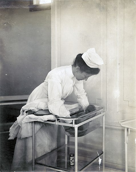 Медсестра купає немовля на виставці дитячих інкубаторів